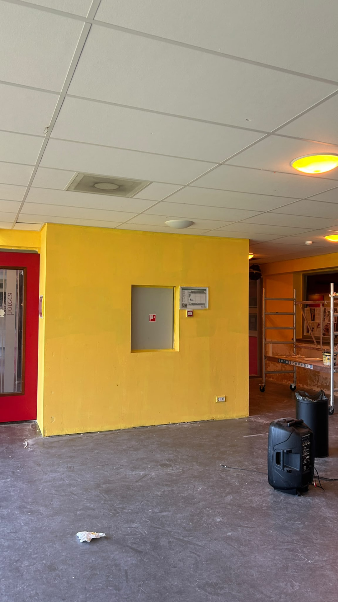 De pas geschilderde gele muur met de rode deuren van het restaurant